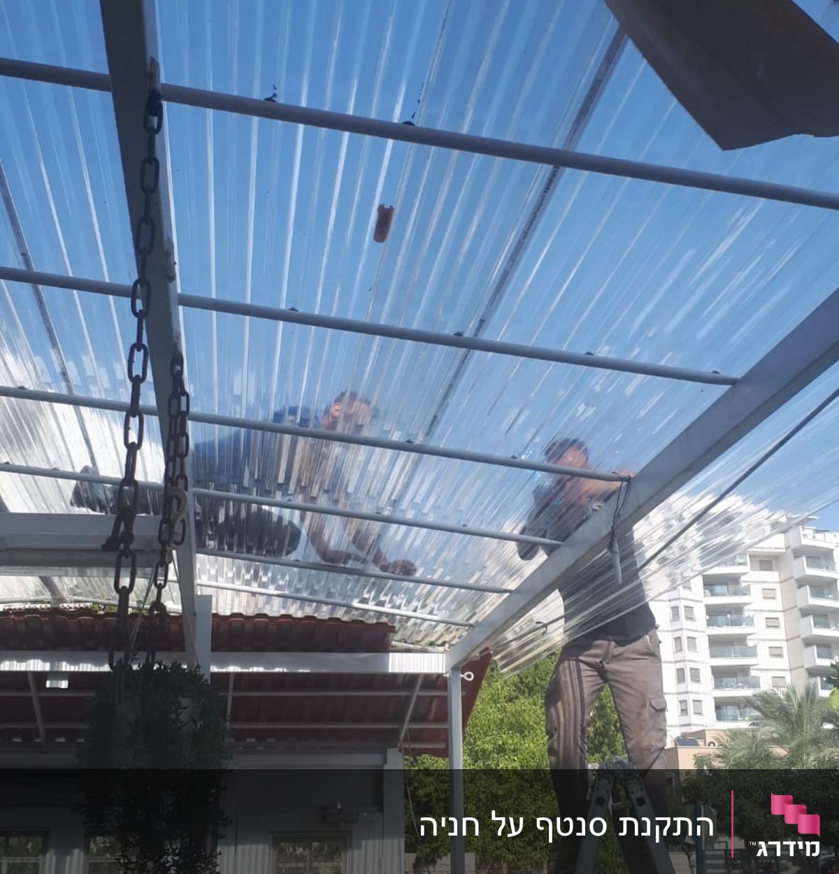 שני אנשים מתקינים גג פלסטיק שקוף על פרגולה